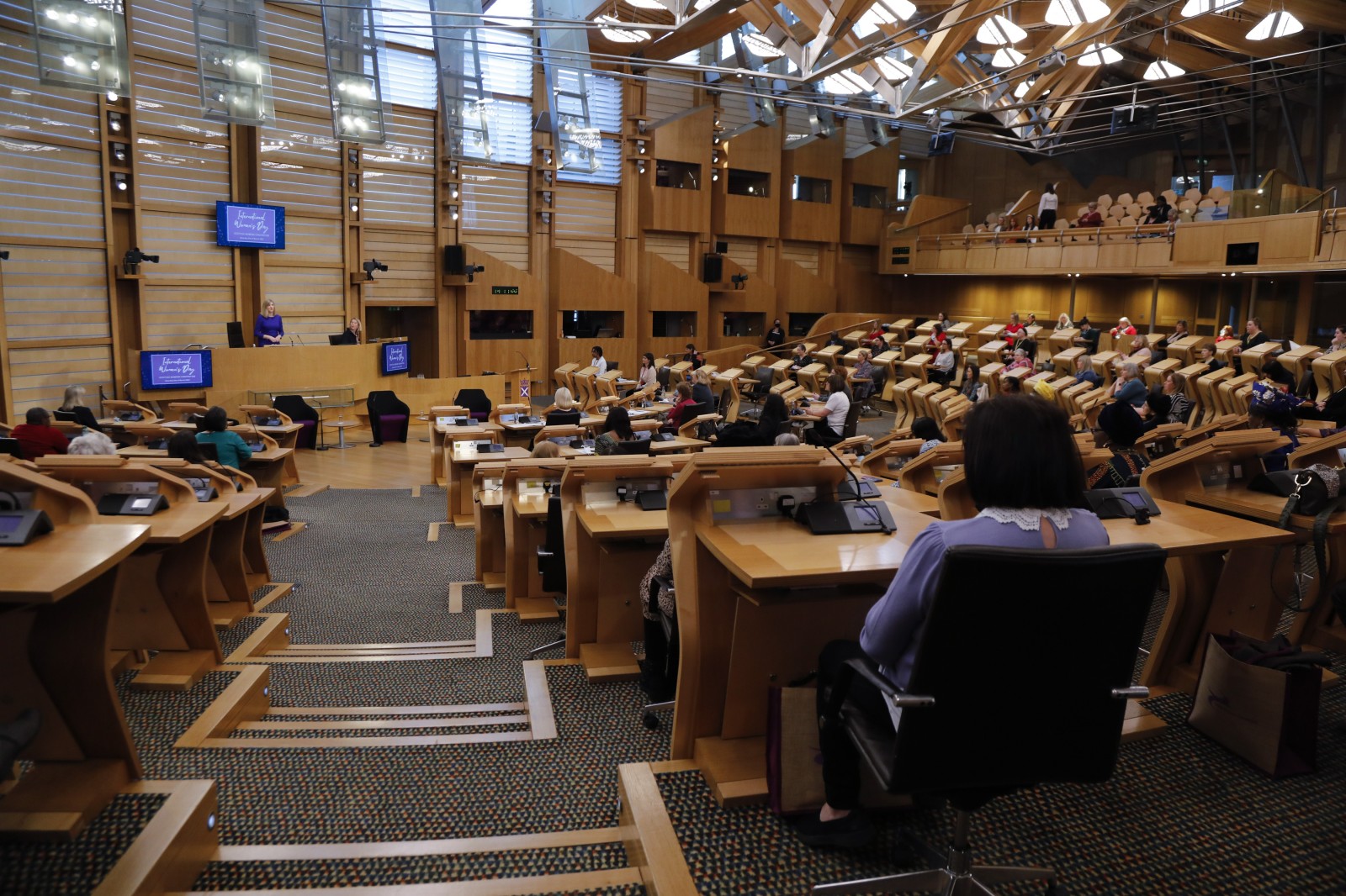Participants look on during keynote speeches during the International Women's Day Conference held in the Debating Chamber of the Scottish Parliament. 05 March 2022.