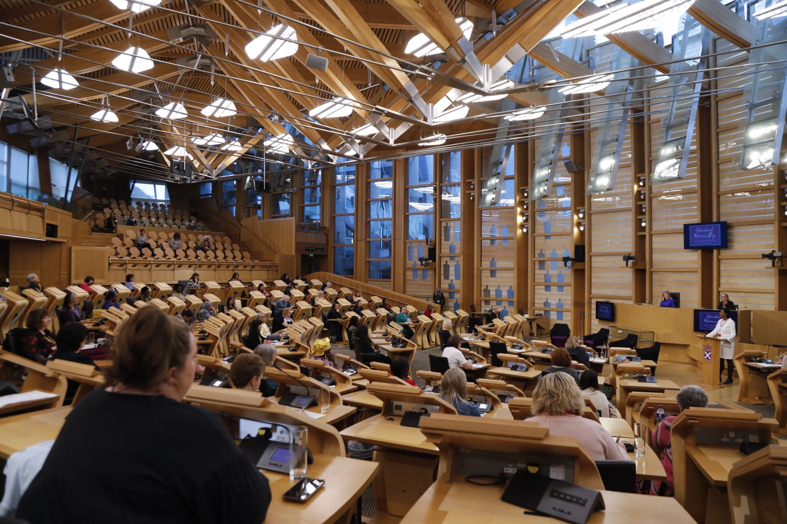 Participants look on during keynote speeches during the International Women's Day Conference held in the Debating Chamber of the Scottish Parliament. 05 March 2022.